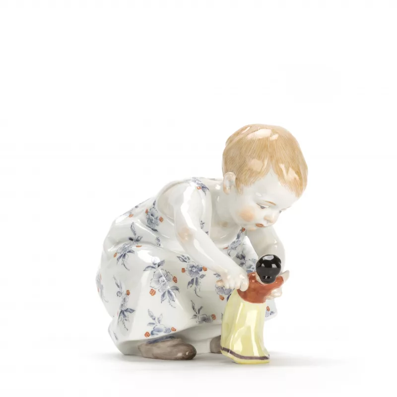 Meissen Hentschelkind 'Hockendes Kind mit einer Puppe in den Händen'